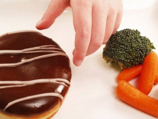 Hand greift nach einem Donut mit Schokolade