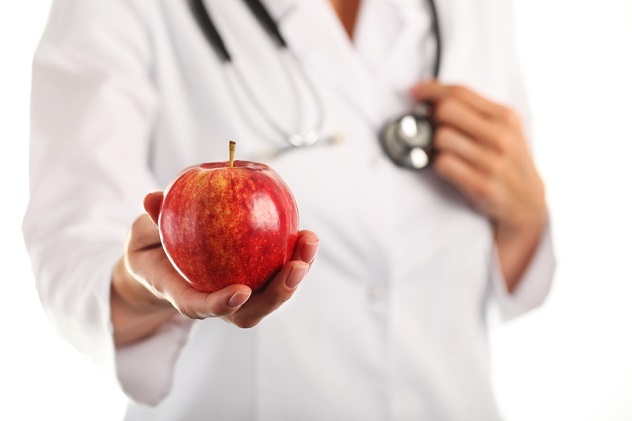Lekár drží jablko v ruke