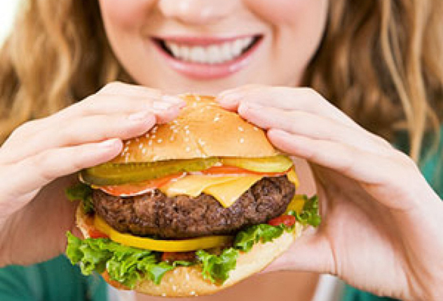 Dievča s úsmevom a jesť hamburger