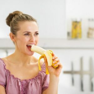 moteris valgo bananą