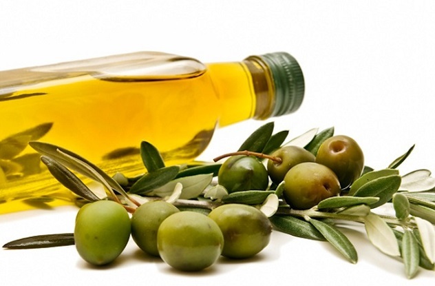 Olivno olje v steklenici in oljk na mizi