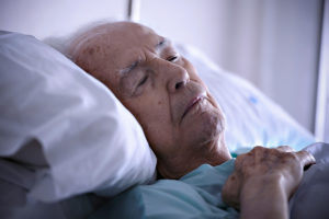 Gammel mand i hospitals seng
