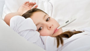 Sygt barn i sengen med feber